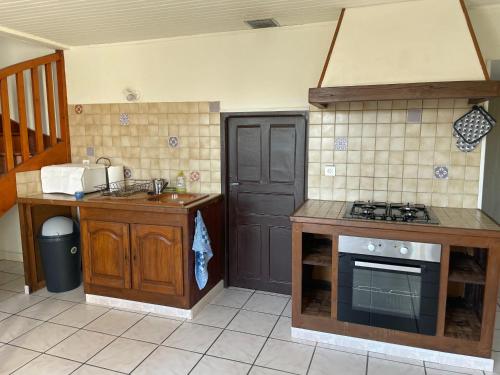 Il comprend une cuisine équipée d'une cuisinière, d'un évier et d'un comptoir. dans l'établissement Maison à la campagne, à Lupersat