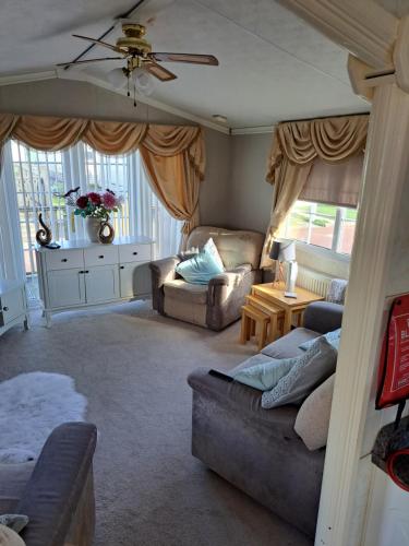 a living room with two couches and a table at Windermere in Morecambe