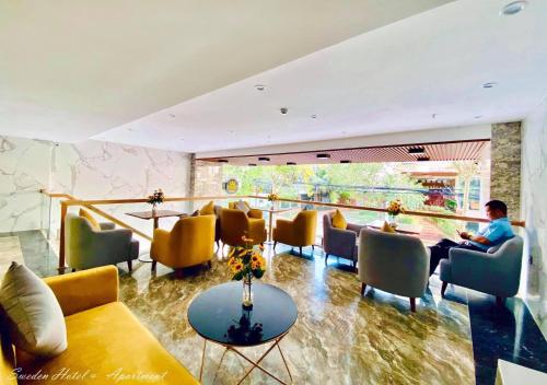 SWEDEN HOTEL and APARTMENT في دا نانغ: شخص يجلس على طاولة في غرفة الانتظار
