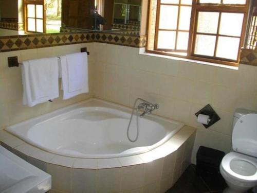 baño con bañera grande y aseo en Tapologo Lodge, en Zeerust