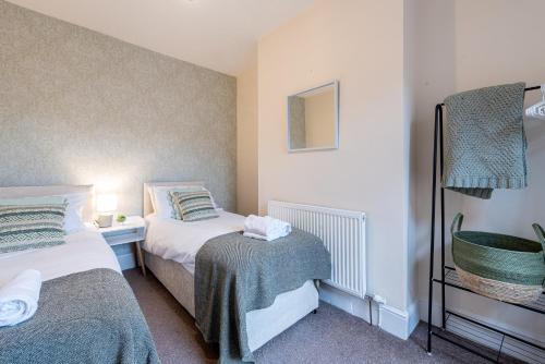 een kleine slaapkamer met 2 bedden en een lamp bij Hope House Chester Sleeps 6 by Heritage Stays in Hough Green
