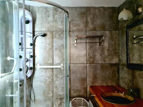uma casa de banho com uma cabina de duche em vidro e um lavatório. em Puerto Esmeralda ESPECTACULAR DEPTO CON VISTA AL LAGO NAHUEL HUAPI em Villa La Angostura