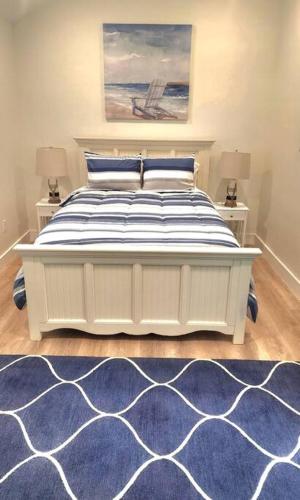 a bedroom with a white bed and a blue rug at Relaxing Retreat and Modern Charm in Historic Saint Augustine in St. Augustine