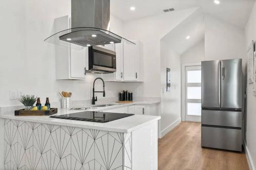a kitchen with white cabinets and a stainless steel refrigerator at Retreat into relaxation sanctuary Saint Augustine in Saint Augustine