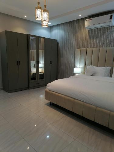 شقة فاخرة حي الرمال في الرياض: غرفة نوم كبيرة بسرير كبير وثريا