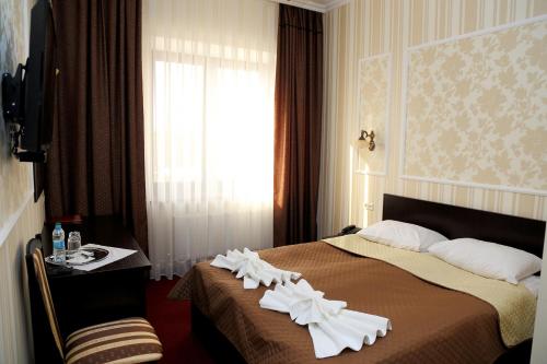 a hotel room with a bed with white flowers on it at BeSt Hotel and Restaurant complex in Dunaivtsi