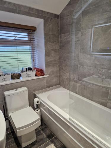 a bathroom with a tub and a toilet and a sink at Ryburn View Cottage in Luddenden Foot