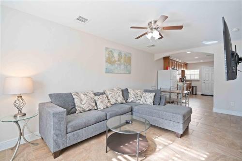 a living room with a couch and a ceiling fan at Pristine & Exquisitely Designed APT 7 Min From TX Med Center in Houston