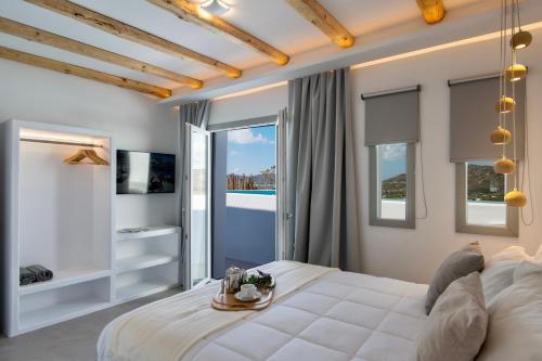 a bedroom with a bed with a view of a pool at Mykonos Village in Ano Mera