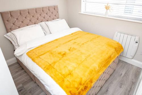 Una cama con una manta amarilla en un dormitorio en ALBERT COURT 
