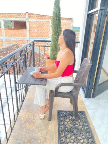 a woman sitting at a table on a balcony at Heinz B. in Santa Ana de los Caballeros