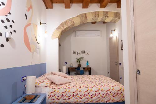 een slaapkamer met een bed en een gewelfde deur bij Trigu & Mangoni in Cagliari