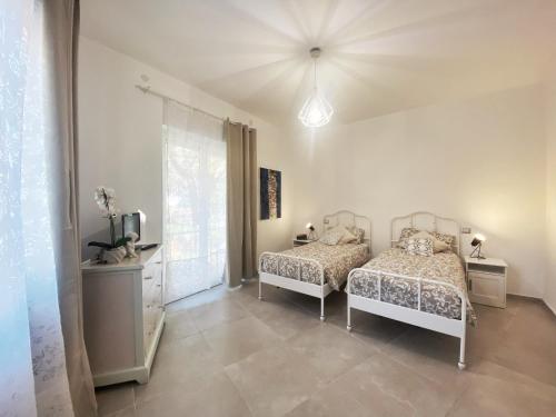 a bedroom with two beds and a television in it at COMFORTABLE SEA HOLIDAYS AND WALKS in Moneglia