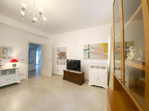 een grote woonkamer met een kroonluchter en een televisie bij COMFORTABLE SEA HOLIDAYS AND WALKS in Moneglia