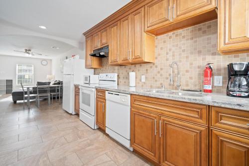 a kitchen with wooden cabinets and white appliances at Pristine & Exquisitely Designed APT 7 Min From TX Med Center in Houston