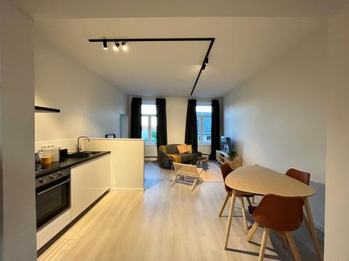 een keuken en een woonkamer met een tafel en stoelen bij Holiday Home La Petite Maison in Gent