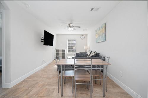 a dining room with a table and a couch at Pristine & Exquisitely Designed APT 7 Min From TX Med Center in Houston