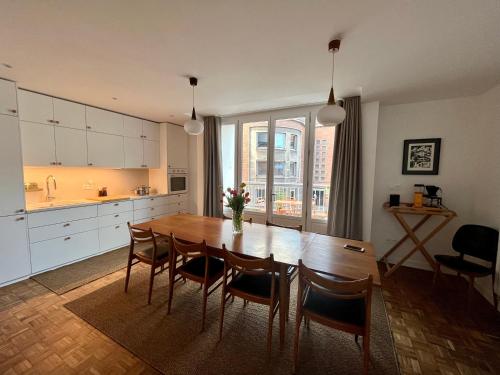 une cuisine avec une table et des chaises en bois ainsi qu'une salle à manger dans l'établissement Le Gite moderne - Gite urbain à Dunkerque, à Dunkerque