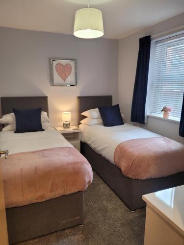 a bedroom with two beds and a window at 1 Merchants Gate - 2 bedroom, city apartment with private parking in York