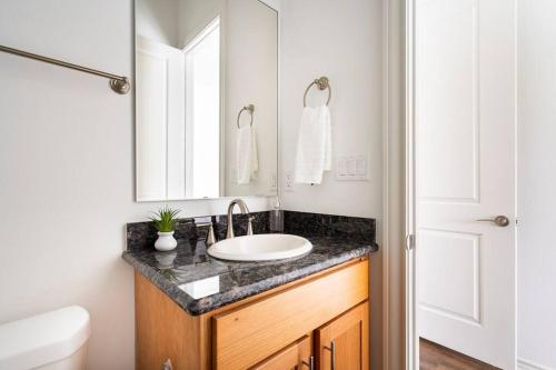 a bathroom with a sink and a mirror at Chic Urban Living Minutes from I-45 and I-610 #A in Houston