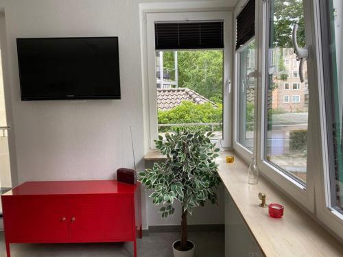 a living room with a red cabinet and a window at City Appartement 1 Hannover Altstadt in Hannover