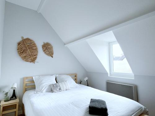 ein Schlafzimmer mit einem weißen Bett und einem Fenster in der Unterkunft L'agapanthe in Saint-Gildas-de-Rhuys