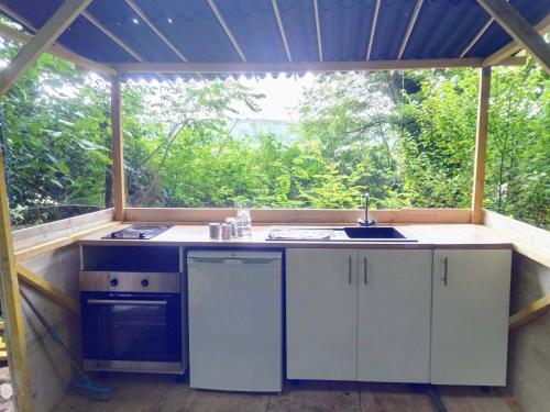 an outdoor kitchen with a sink and a window at Gîtes insolites proche Nancy in Marbache