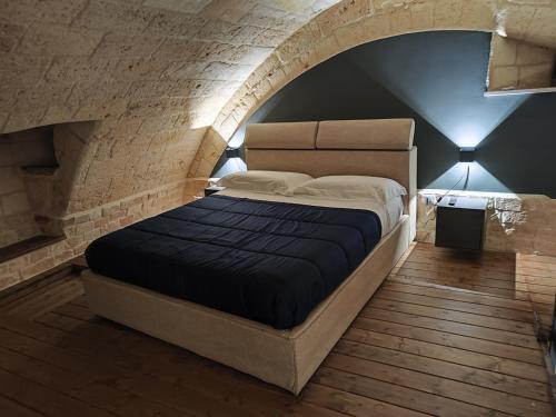 アンドリアにあるROBERTO's Guest Houseのレンガの壁に大きなベッドが備わるベッドルーム1室が備わります。