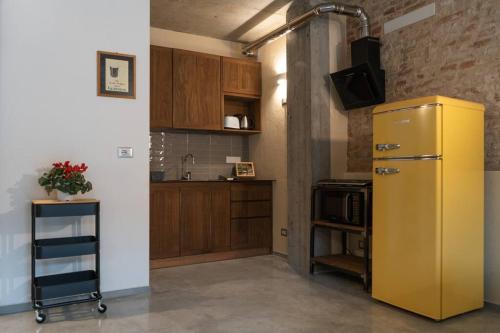 a kitchen with a yellow refrigerator and a microwave at Recinto Nobili 2 - private parking vista cortile in Asti