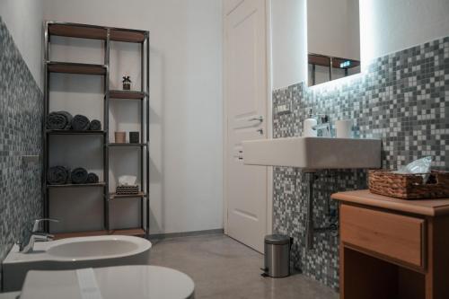 a bathroom with a sink and a toilet and a mirror at Recinto Nobili 2 - private parking vista cortile in Asti
