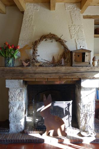 a fireplace with a wooden animal in front of it at Le Montillon in Tour-en-Sologne