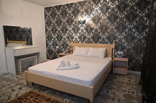 Un dormitorio con una cama con dos toallas blancas encima. en Pensiunea Savas, en Costinesti