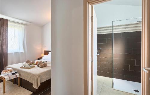 - une chambre avec un lit et une douche en verre dans l'établissement 5 Bedroom Awesome Home In Naselje Muzini, à Tomišići