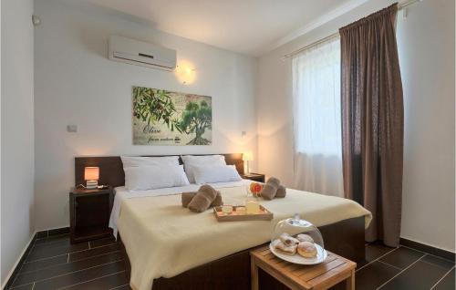 - une chambre avec un lit et un plateau de nourriture dans l'établissement 5 Bedroom Awesome Home In Naselje Muzini, à Tomišići