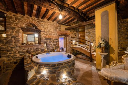 een grote badkamer met een groot bad in een stenen gebouw bij San Lazzo Luxury Room - ROOM & PERSONAL SPA in Castiglion Fiorentino