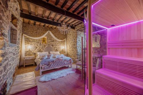 a bedroom with a bed in a stone wall at San Lazzo Luxury Room - ROOM & PERSONAL SPA in Castiglion Fiorentino
