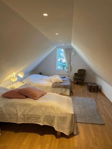 sypialnia na poddaszu z 2 łóżkami i oknem w obiekcie Lilla Villan w mieście Höganäs