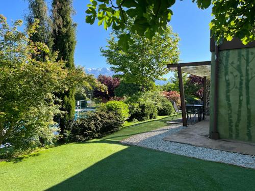 a garden with a green lawn and a gazebo at Veragua. Glamping y Apartamentos turísticos in Villanueva de la Vera