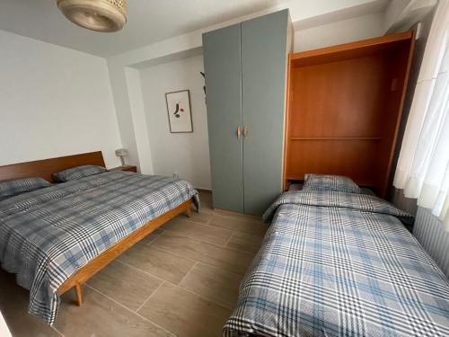 una camera con 2 letti e un armadio di Appartement Luxembourg centre a Lussemburgo