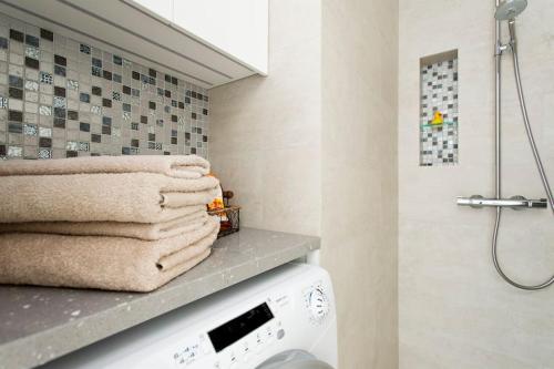 a bathroom with a pile of towels on a shelf at Stylish studio in the centre in Helsinki
