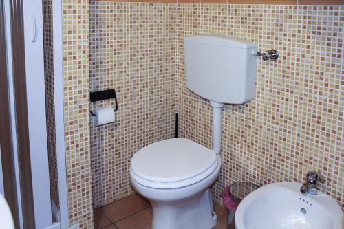a bathroom with a white toilet and a sink at Guest House La Casetta in Piazza Armerina