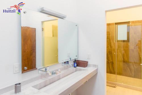Casa Huitzil - La mejor casa de Malinalco con alberca y jacuzzi climatizados في مالينالكو: حمام مع حوض ومرآة