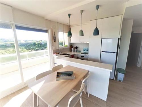 une cuisine avec une table en bois et une grande fenêtre dans l'établissement Paraíso, à Miami Platja