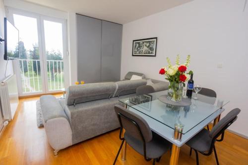 ein Wohnzimmer mit einem Sofa und einem Tisch mit Blumen in der Unterkunft Bella vista - cozy apartment with a great view in Split