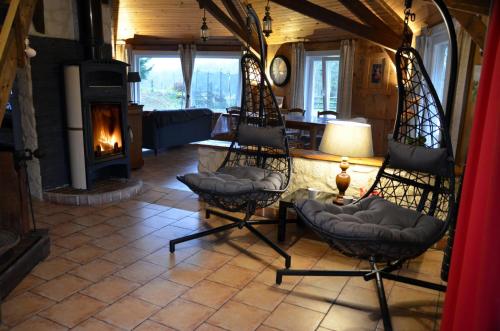 - un salon avec deux chaises et une cheminée dans l'établissement Gîte le Manège Normand, à Grand Camp