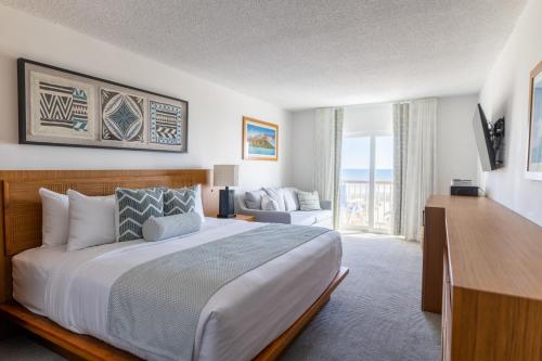 a bedroom with a large bed and a living room at Mahalo Diamond Beach Resort in Wildwood Crest