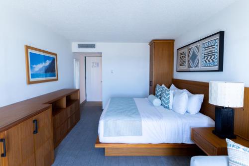 a hotel room with a bed and a lamp at Mahalo Diamond Beach Resort in Wildwood Crest