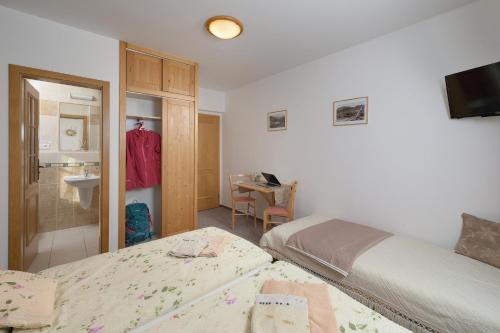 a small bedroom with two beds and a bathroom at U Novotných in Špindlerův Mlýn