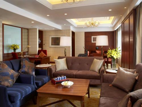 a living room with couches and a table at Shangri-La Baotou in Baotou