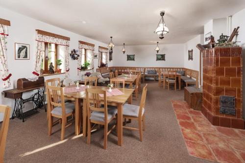 a restaurant with wooden tables and chairs and a fireplace at U Novotných in Špindlerův Mlýn